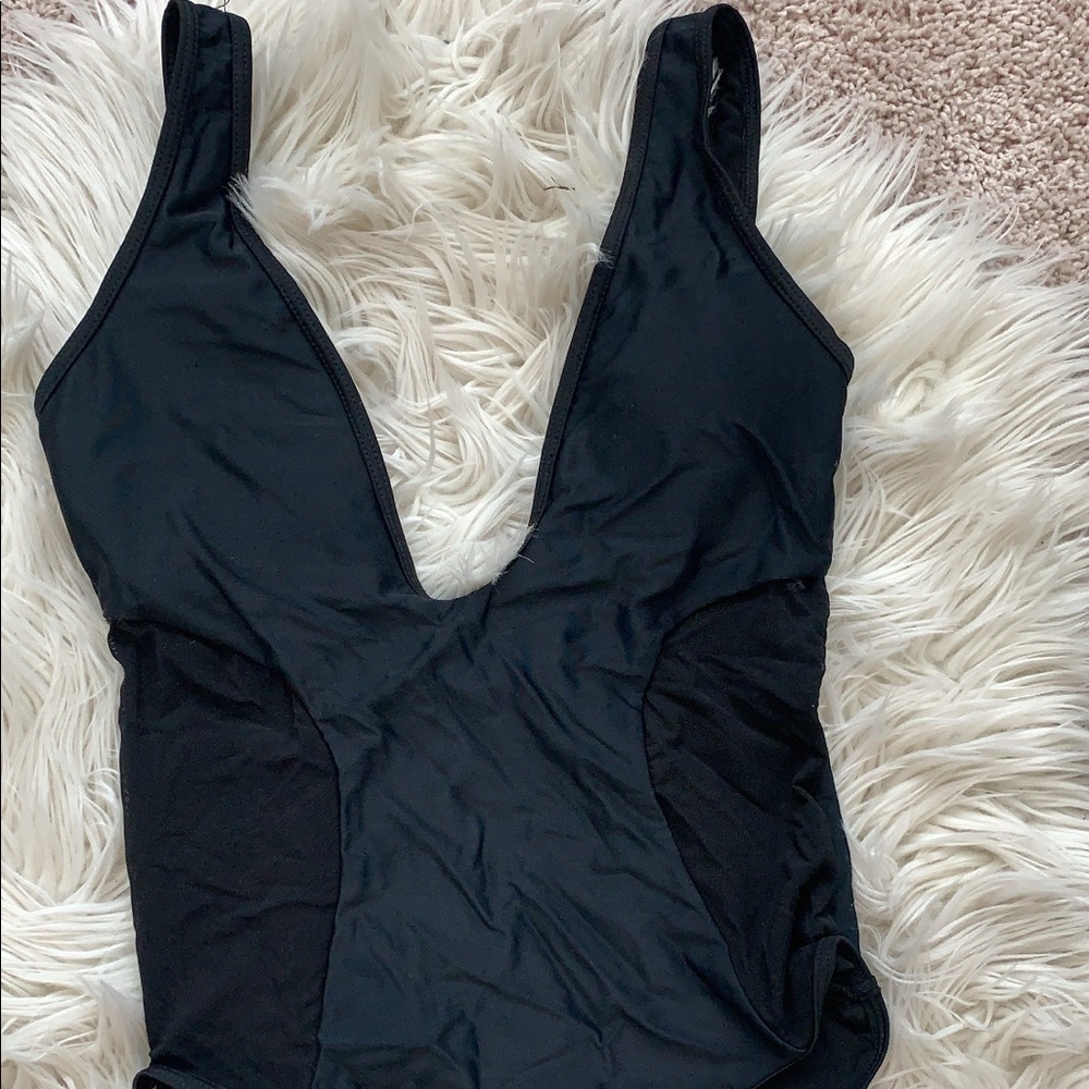 Black one piece, low cut never worn